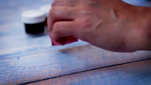 Man painting wooden table with sponge — Stock Video