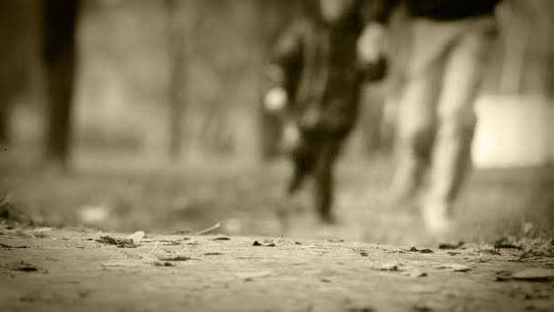 Ancien effet film : père et fils, faire du jogging dans le parc automnal — Video