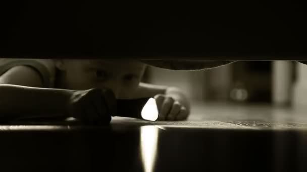 ein kleiner Junge mit Pocket Torch, tastend um unter dem Bett