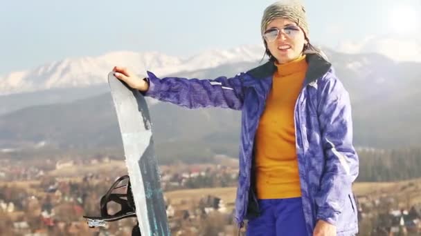 Ski-Saison in den Bergen. Attraktive Mädchen mit Snowboard — Stockvideo