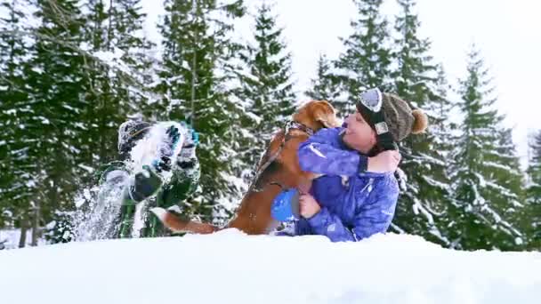 Mother and son playing with beagle dog in deep snow — Stock Video