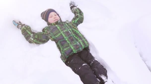 男孩制作雪天使 — 图库视频影像