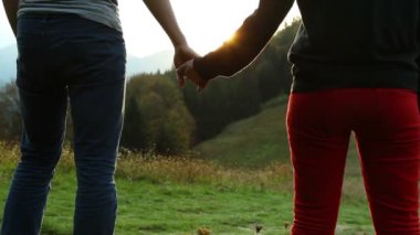 Romantik gençler çift günbatımı dağ yürüyüş sırasında bekliyor yürümek