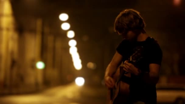 Joven rockero a guitarrista en el tráfico de la noche calle — Vídeos de Stock