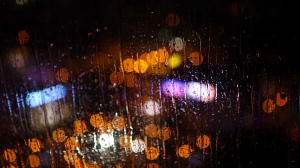 在雨中通过运行水滴巴统，格鲁吉亚湿玻璃看到模糊的夜晚城市的灯光. — 图库视频影像