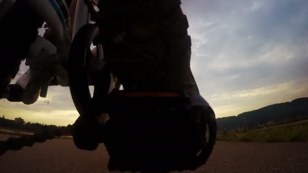 Niño va en amanecer delante de la bicicleta por la carretera asfaltada — Vídeo de stock