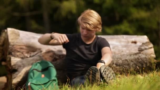 Young man enjoy the sun rays screw up one's eyes during forest walk rest — Stock Video