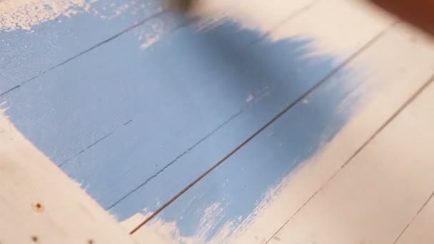 Processus de peinture de planche de bois : un artiste applique une couleur bleue avec une brosse — Video