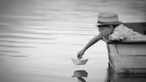 Boy sets paper ship off to sail — Stock Video