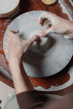 Üst düzey kadınların elleri çömlekçi çarkında kendi atölyelerinde gri çevre dostu kil kaplar yaratırlar. Satılık yaratıcı faaliyetlerin sonucu. Yaratıcı bir iş..