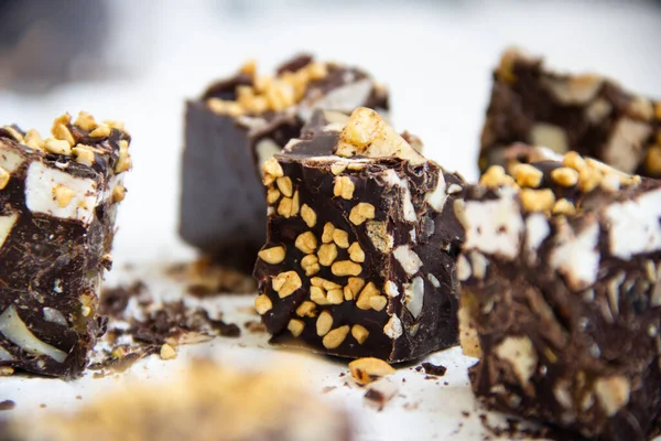 Kabarmış pirinç, fındık ve marşmelov ile yakın plan çikolatalı parçalar, bulanık bir arka planda