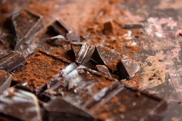 Kahverengi arka planda kakao tozu olan çikolatalı çikolata, yakın plan manzaralı.