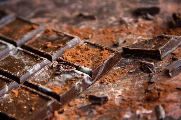 Kahverengi arka planda kakao tozu olan çikolatalı çikolata, yakın plan manzaralı.