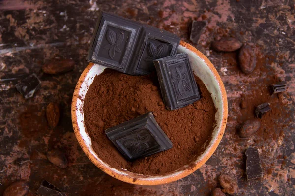 Kil bardaktaki acı çikolata, arka planda bulanık kakao, üst manzara.