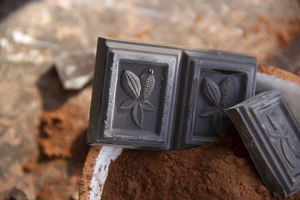 Kil bardaktaki acı çikolata. Arka planda bulanık kakao. Yakın plan.