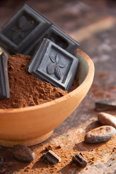 Kil bardaktaki acı çikolata. Arka planda bulanık kakao. Yakın plan.