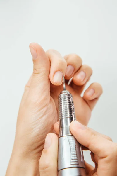 Manicure milling cutter close-up cuticle remover. The manicure machine removes cuticles and makes your nails attractive and aesthetically beautiful and well-groomed.