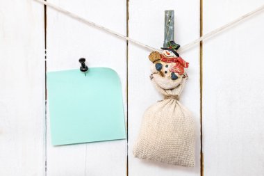 Noel kardan adam clothespin çuval ve sabitlenmiş not kağıdı tutan