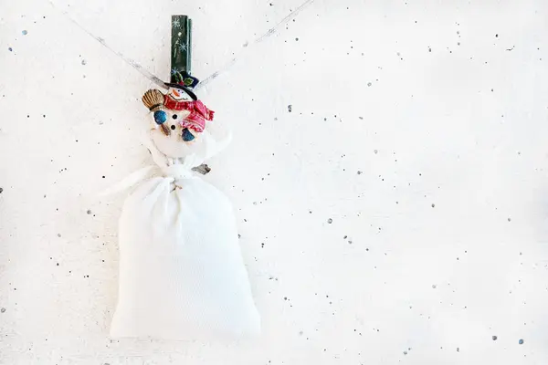 Christmas snowman clothespin holding big sack — Stock Photo, Image