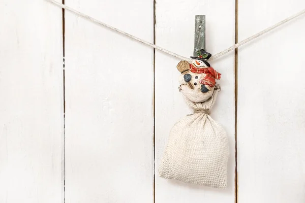 Christmas snowman clothespin holding sack — Stock Photo, Image