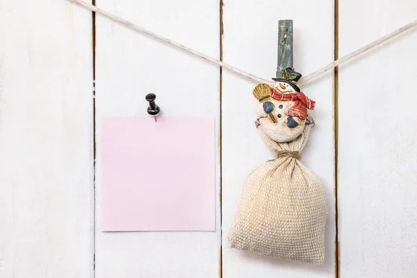 Christmas snowman clothespin holding sack and pinned note paper — Stock Photo, Image