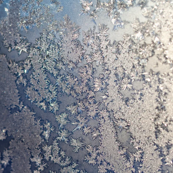 Flocos de neve e gelo na janela congelada — Fotografia de Stock
