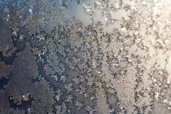Снежинки и лед на замороженном окне — стоковое фото