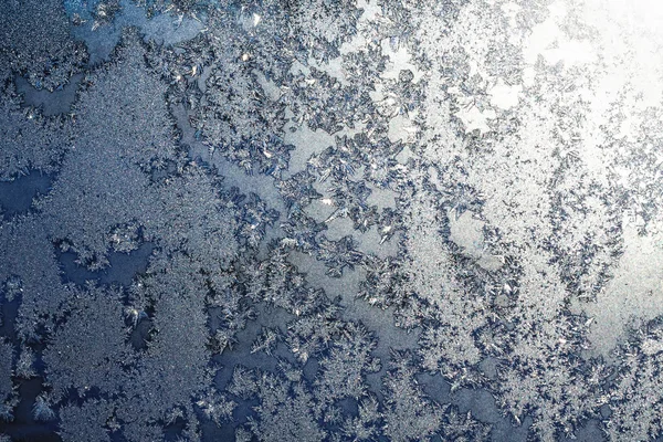 Snowflakes and ice on frozen window — Stock Photo, Image