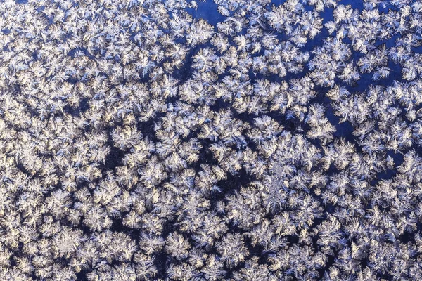 Flocos de neve na janela congelada — Fotografia de Stock