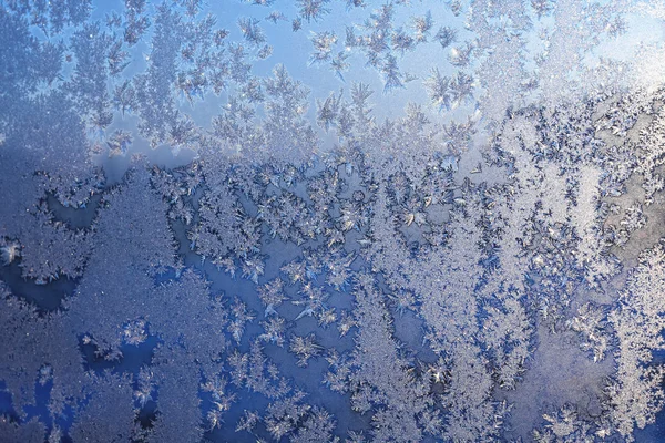 Flocos de neve e gelo na janela congelada — Fotografia de Stock