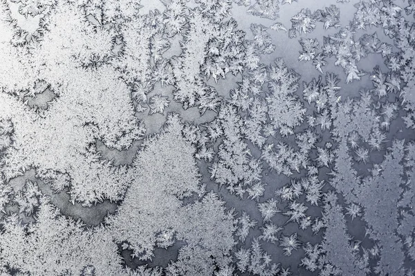 Snowflakes and ice on frozen window — Stock Photo, Image