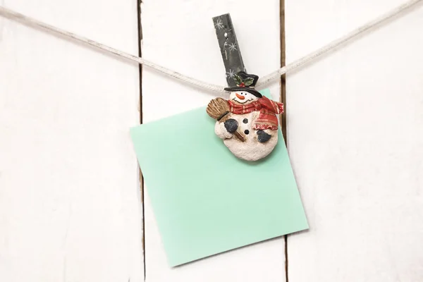 Christmas snowman clothespins holding blank note paper — Stock Photo, Image