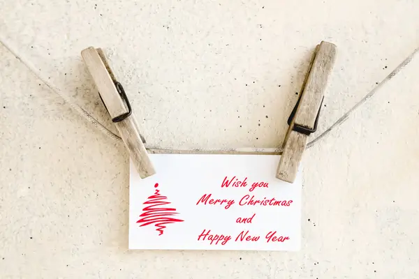 Clothespins holding christmas greeting card — Stock Photo, Image