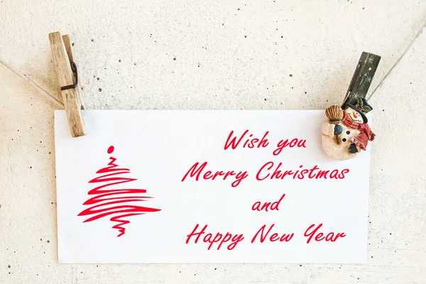 Christmas snowman clothespins holding greeting card — Stock Photo, Image