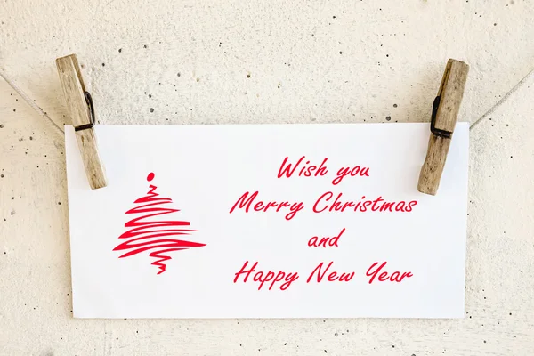 Clothespins holding christmas greeting card — Stock Photo, Image