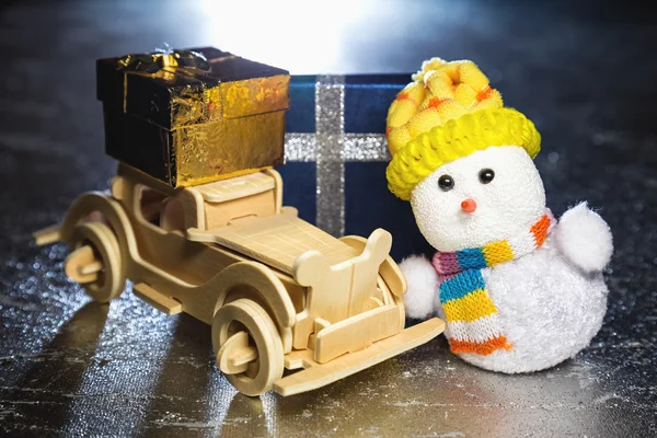 Snowman y coche de madera con cajas de regalo — Foto de Stock