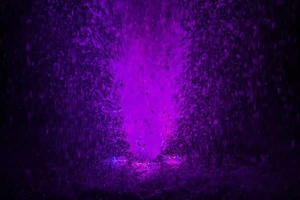 Colorful fountain splashes violet color — Stock Photo, Image