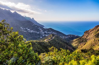 Bulutlar okyanus yakınındaki dağlarla köyde