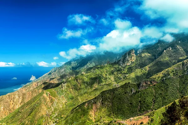 Bulutlar ve Yeşil dağlar ya da Okyanusu yakınlarındaki kayalar — Stok fotoğraf