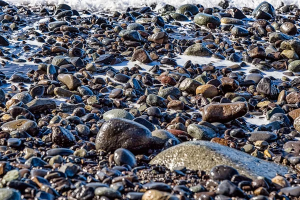Piedras con espuma en la orilla de la playa —  Fotos de Stock