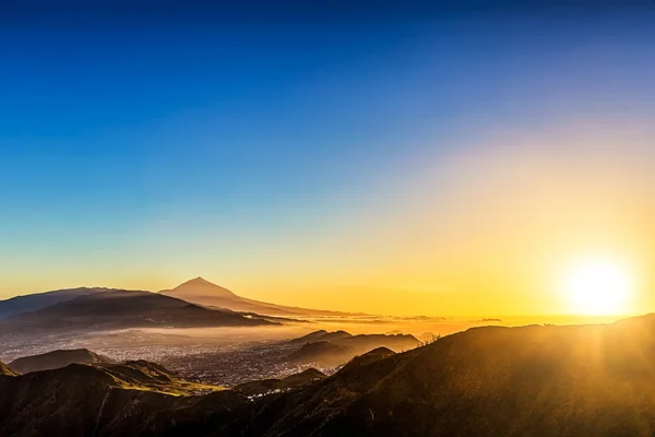 Sole con la luce del sole sulle montagne sul cielo blu — Foto Stock