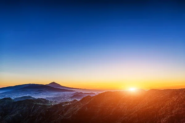 Sun over mountains on blue sky