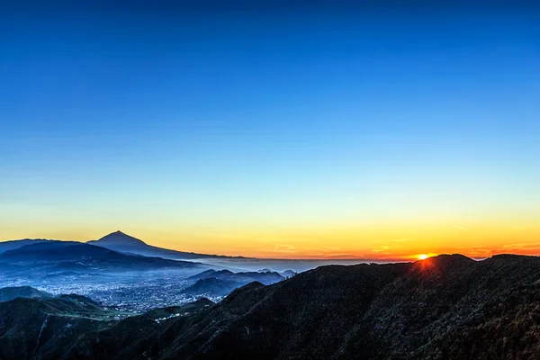 Güneş mavi gökyüzü dağlardaki üzerinde — Stok fotoğraf