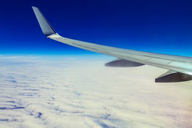 Uçak kanadı yukarıda gökyüzü ve bulutlar