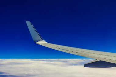 Uçak kanadı yukarıda gökyüzü ve bulutlar