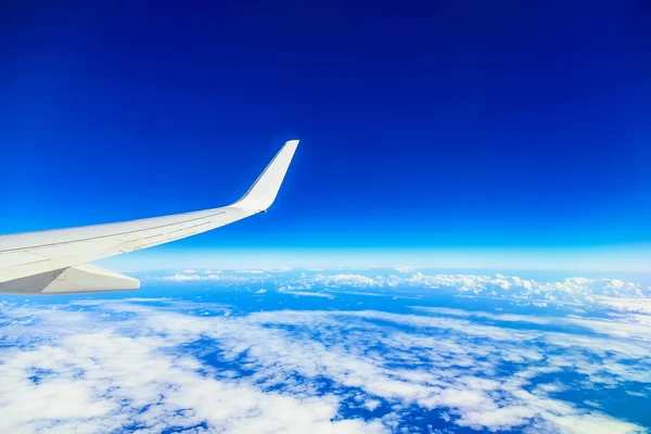 Plane Wing above Sky and Clouds