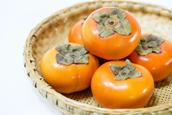 Fresh ripe persimmons on Japanese bamboo basket — Stock Photo, Image