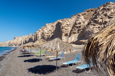 Santorini Island, Yunanistan beyaz rock yakınındaki Plajda şemsiye ve şezlong