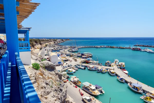 Kijk op de kleine haven en vissersboten geparkeerd in de buurt van pier van Vlychada stad op Santorini eiland, Griekenland — Stockfoto