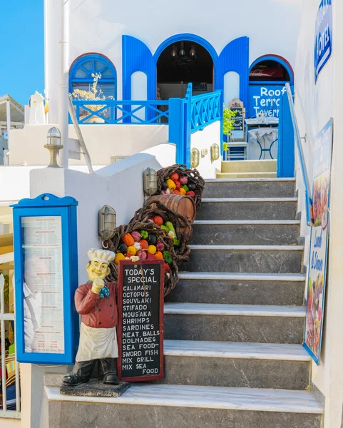 Entrance to traditional Greek tavern , decorated with vegetables and figure of cook — Stock Photo, Image